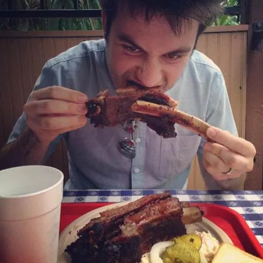 Photo of a man eating very large ribs. He’s quite handsom and also humble. The photo was clearly taken more than a decade ago.